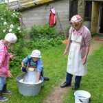 Lasten perinnepäivä koostuu työkokeiluista ja leikeistä. Kuvassa Eila Lempinen näyttää pyykinpesua pyykkilaudalla.