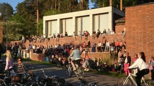 Jyväskylän yliopisto. Yliopiston edessä istuu paljon nuoria.
