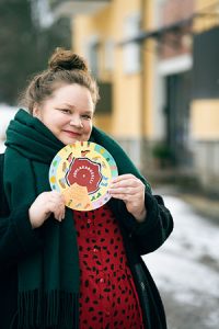 Marja Laine, Kulttuuri- ja uskontofoorumi Fokuksen toiminnanjohtaja, Haagassa. Taustalla tyypillinen keltainen 50-luvun kerrostalo.