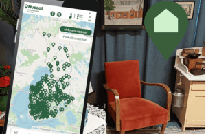 karttanäkymä puhelimen näytöllä ja taustalla nojatuoli sekä taulu