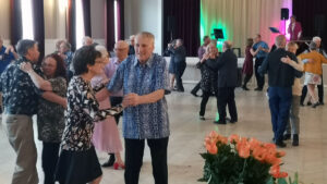 Glada människor dansar på föreningshuset i Torneå. I förgrunden syns äldre personer.