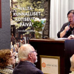 Tuija Ahola puhujan paikalla kokoussalissa.