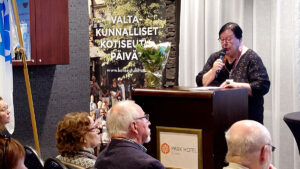 Tuija Ahola puhujan paikalla kokoussalissa.