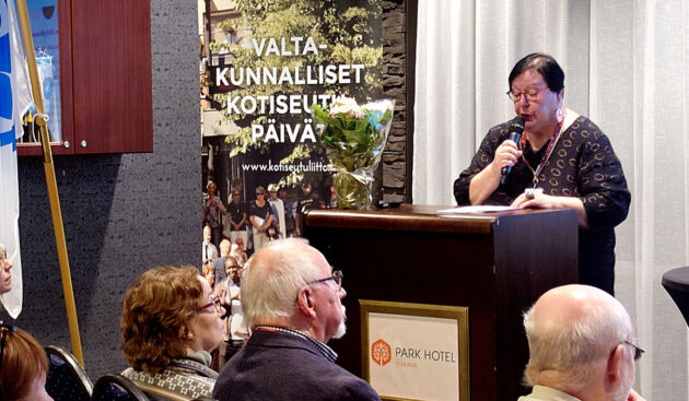 Tuija Ahola puhujan paikalla kokoussalissa.